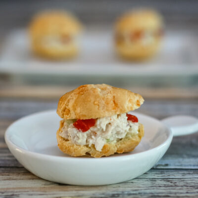 A chicken salad puff in a small appetizer dish.