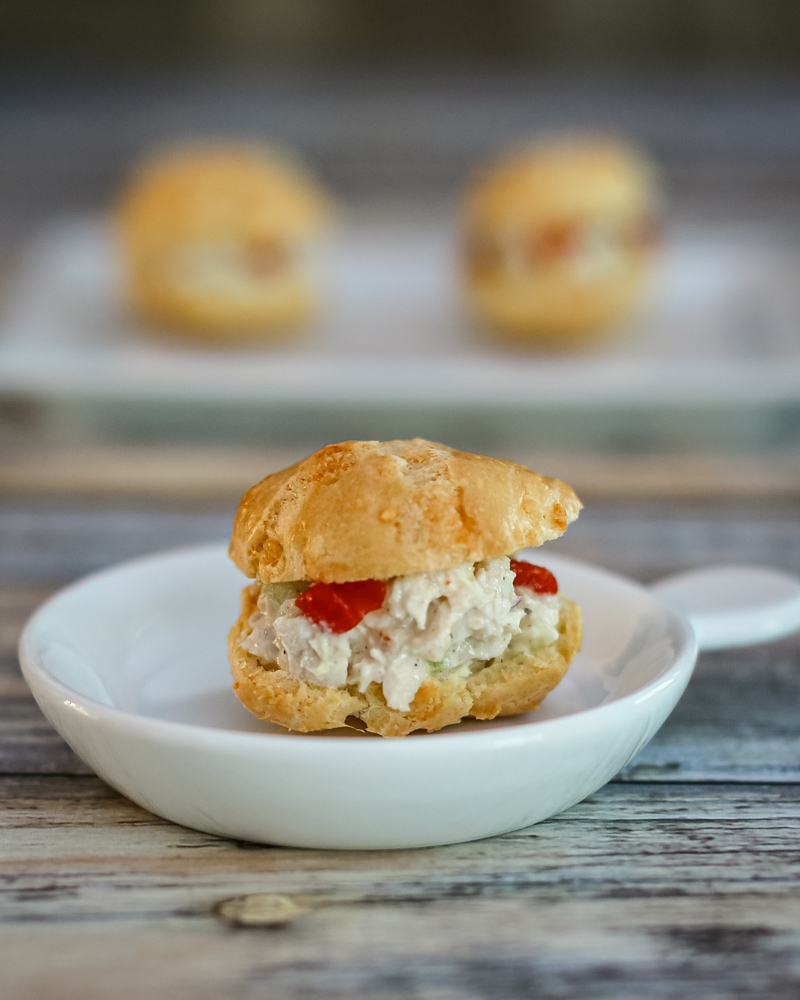 A chicken salad puff in a small appetizer dish.