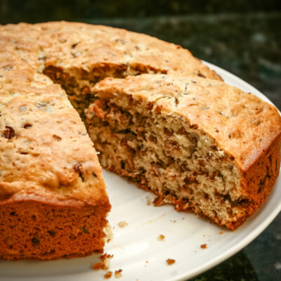 Chocolate chip cake on a light colored cake plate.