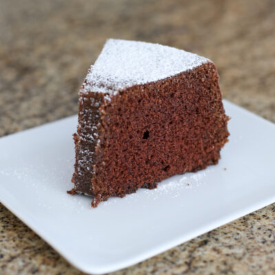 Chocolate sponge cake sliced and dusted with powdered sugar in close-up.