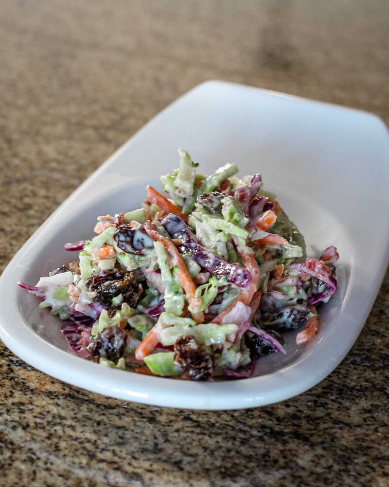 Creamy colorful coleslaw on a small white plate.