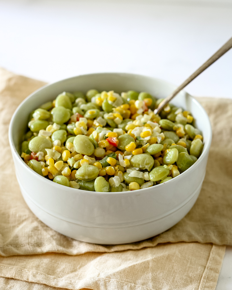 a serving bowl of succotash with corn and lima beans