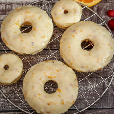 Cranberry orange donuts on a cooling rack.