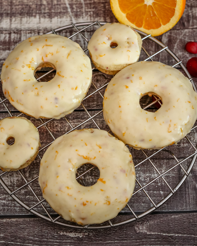 Cranberry orange donuts on a cooling rack.