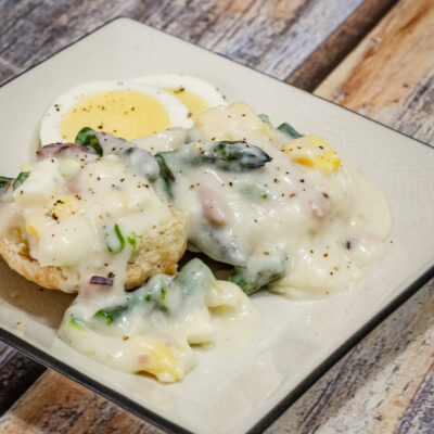 creamed ham and asparagus with hard boiled eggs on a plate