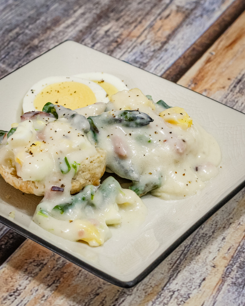 creamed ham and asparagus with hard boiled eggs on a plate