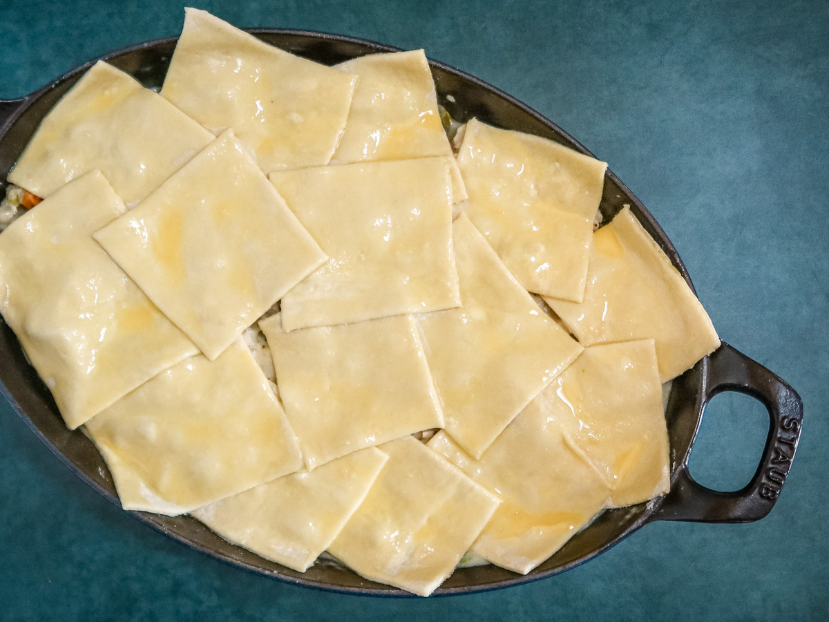 chicken pot pie covered with squares of puff pastry, ready to bake.