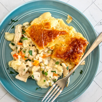 A serving of chicken pot pie that is topped with patchwork puff pastry.