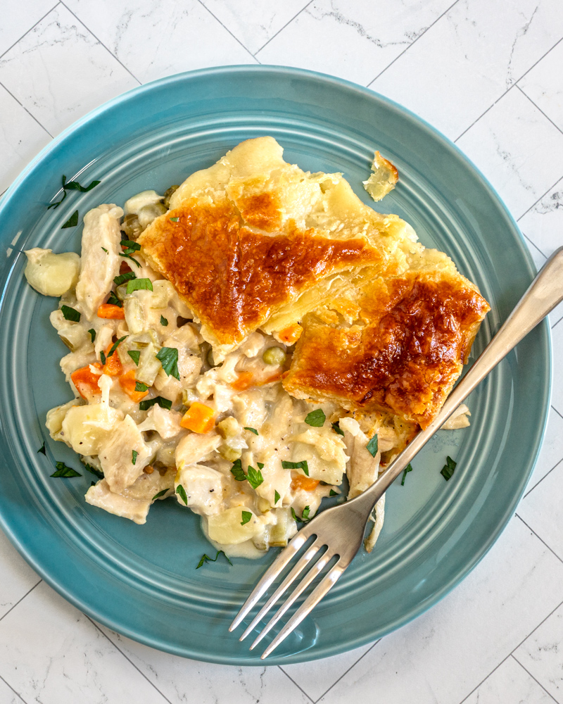 A serving of chicken pot pie that is topped with patchwork puff pastry.