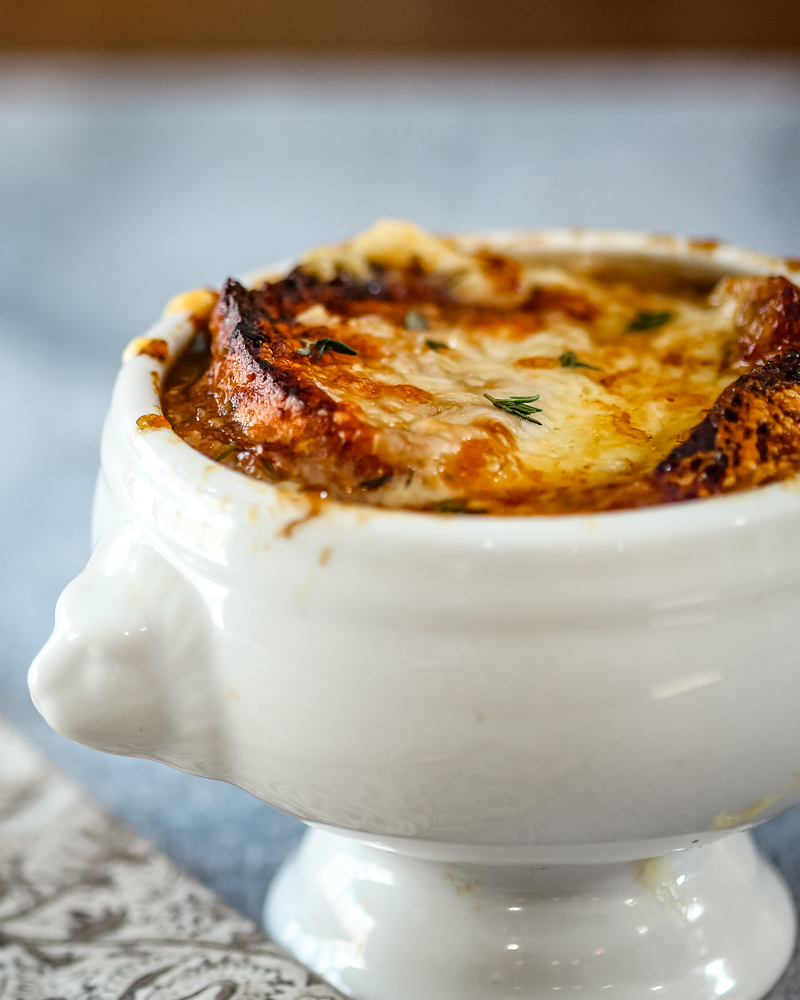 A lion's head bowl of French onion soup.