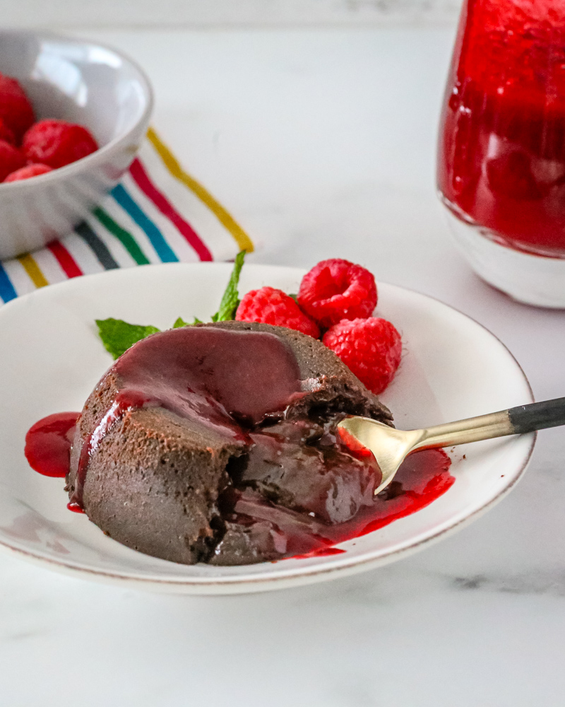 chocolate molten lava cake on a plate with raspberries and mint