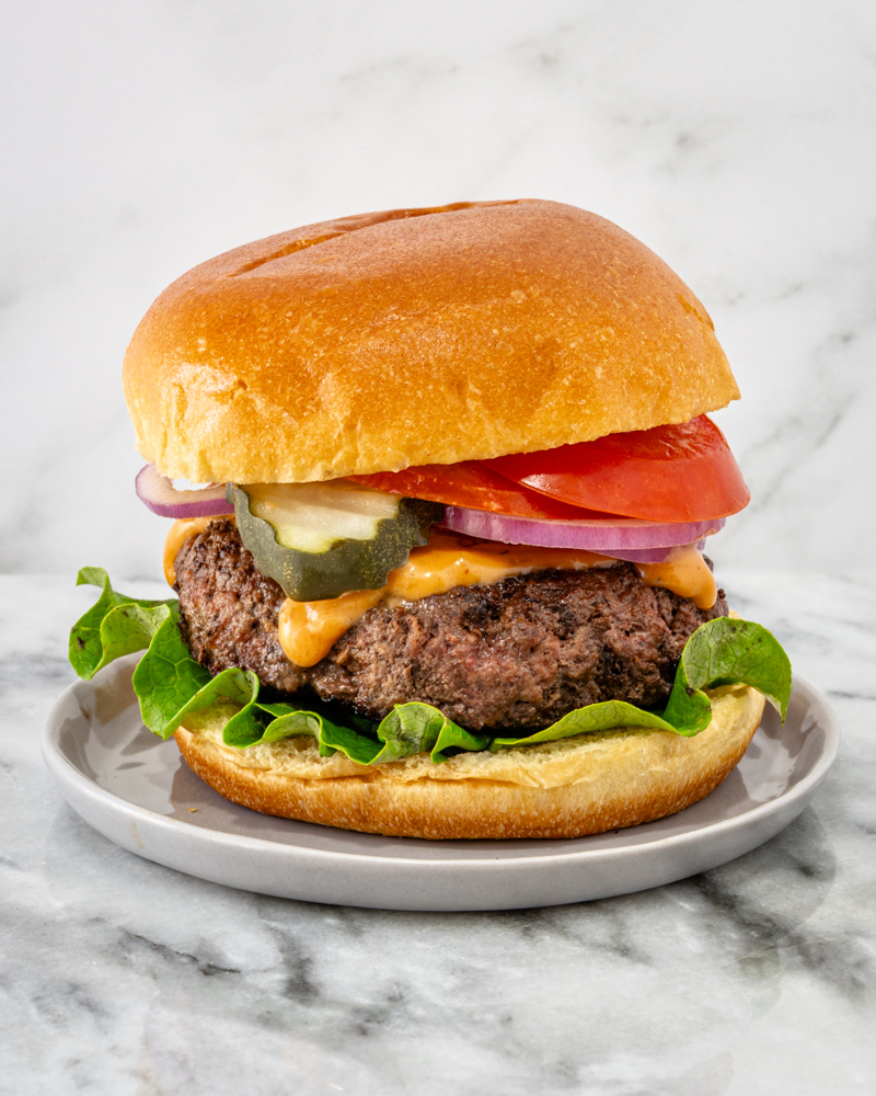 A mozzarella burger with toppings on a brioche bun.