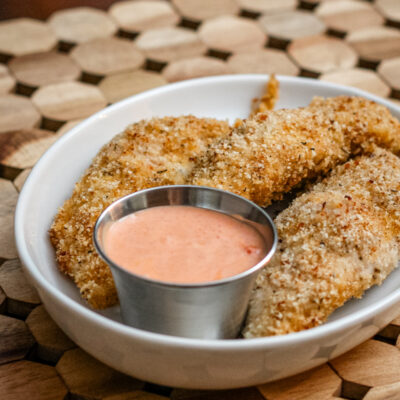 bacon and panko coated chicken tenders on a plate with dip