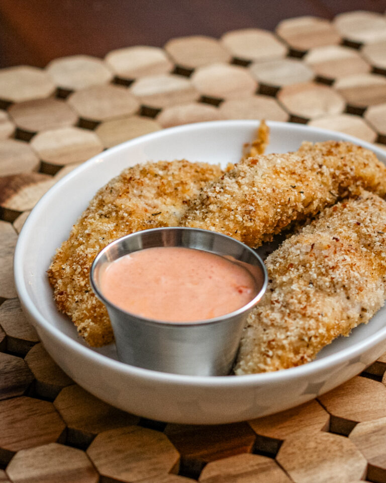 bacon and panko coated chicken tenders on a plate with dip