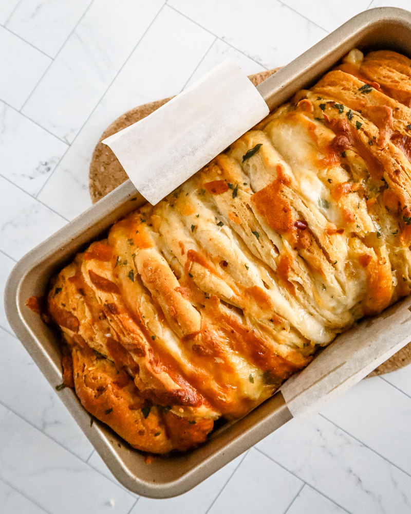 cheese and garlic pull apart bread baked with biscuits, in the baking pan.