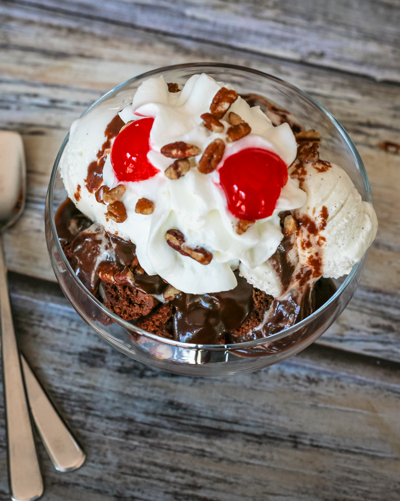 Chocolate sauce on ice cream with whipped cream and cherries