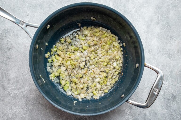 Onion and celery in a skillet cooking with butter.