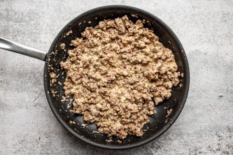 The ground beef and secret sauce are combined in the skillet.