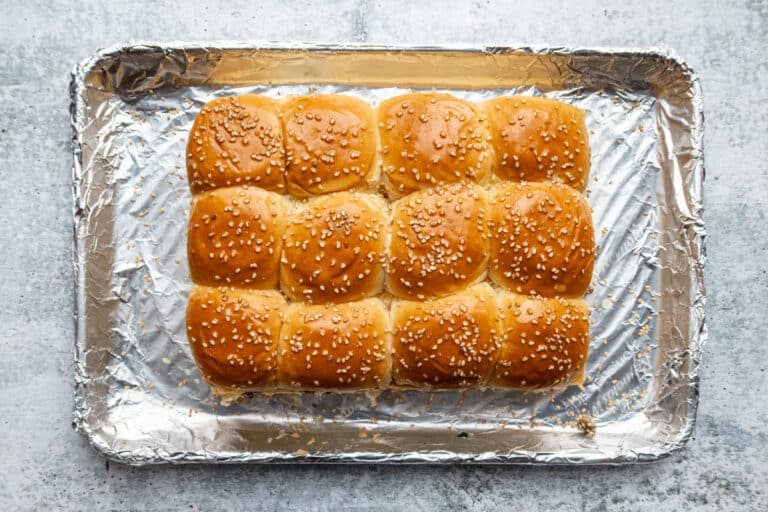 The tops are placed on the filling and brushed with melted butter, then sprinkled with sesame seeds.