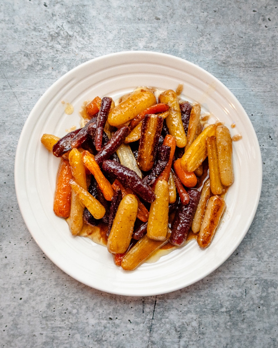 A plate of glazed roasted baby rainbow carrots.