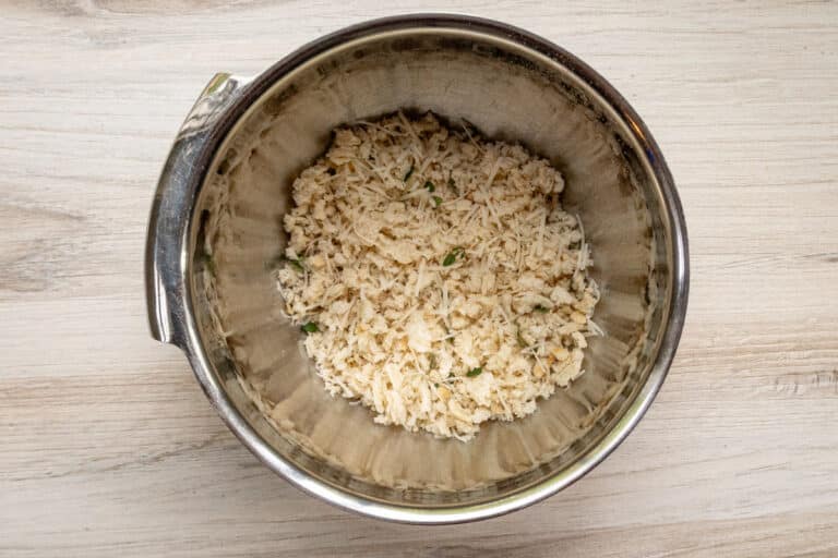 Fresh breadcrumbs in a bowl with Parmesan cheese.