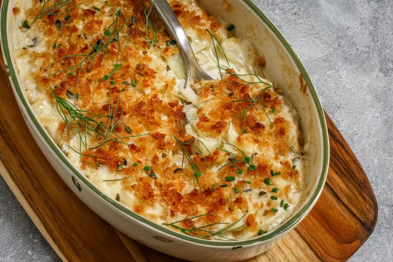 Closeup of the baked fennel gratin, finished with fennel fronds and chives.