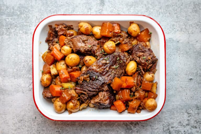 Yankee pot roast and vegetables in a tray while gravy is made.