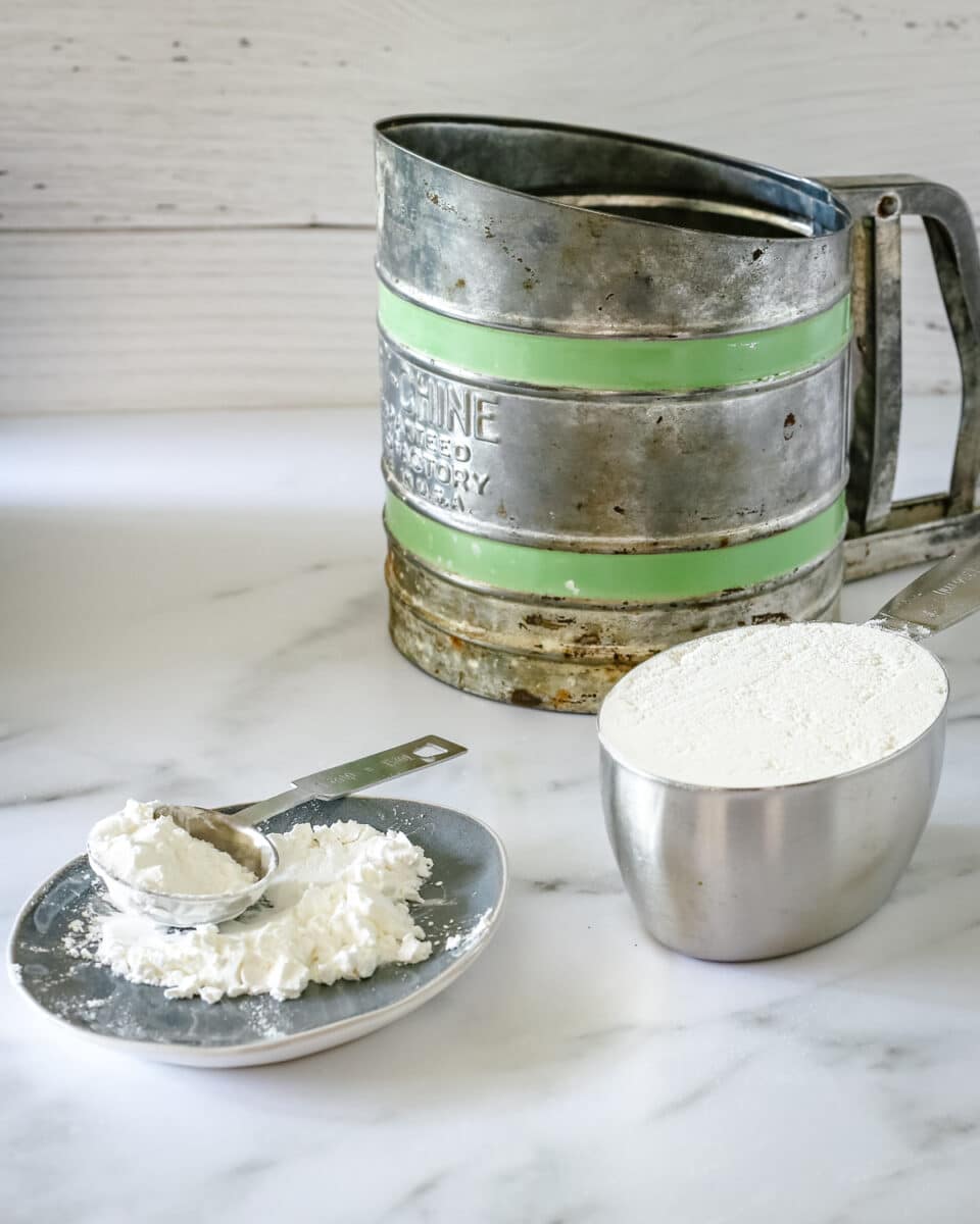 Flour being measured with a sifter in the background.