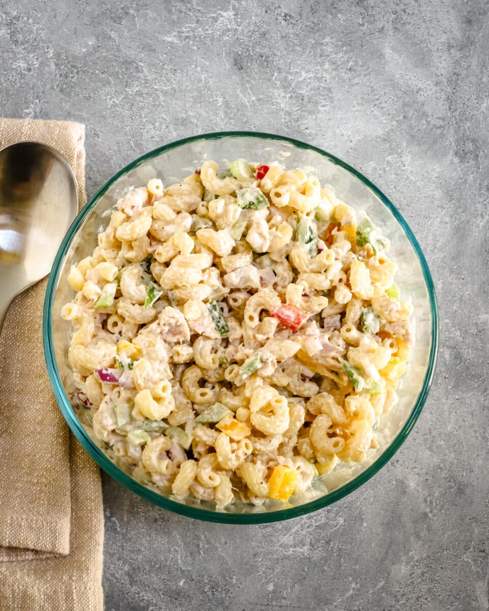 A bowl of classic tuna and macaroni salad with bell peppers, celery, and a simple mayonnaise dressing.