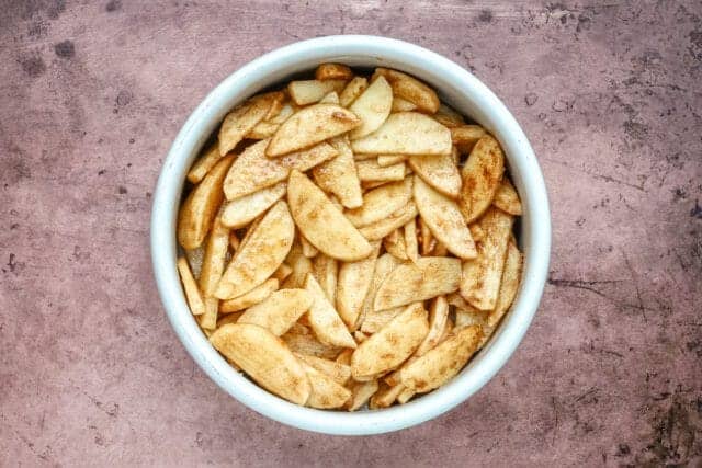Crunchy homemade potato chips in a white bowl.