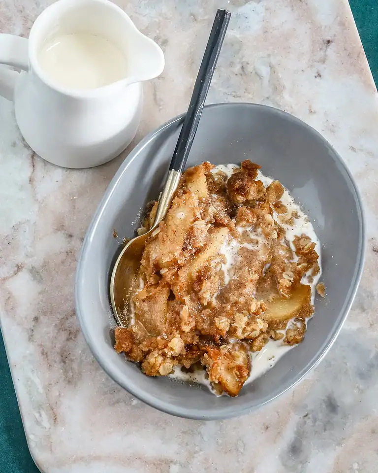 Fried apple dessert with crispy topping and milk.