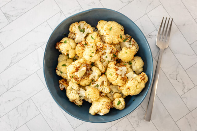 air fryer roasted cauliflower in a bowl with fork.