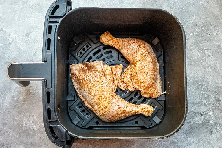 Whole chicken leg quarters in the air fryer basket