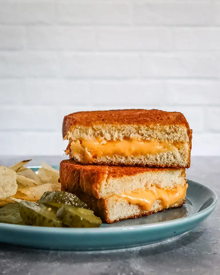Deep-fried grilled cheese sandwich with melted cheese inside.