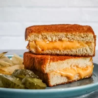 Golden browned grilled cheese sandwich with melted cheese inside.