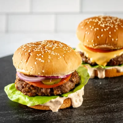 Juicy beef burgers with fresh vegetables and sesame seed buns.