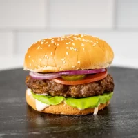 Juicy cheeseburger with lettuce, tomato, pickles, onions, and sesame bun.