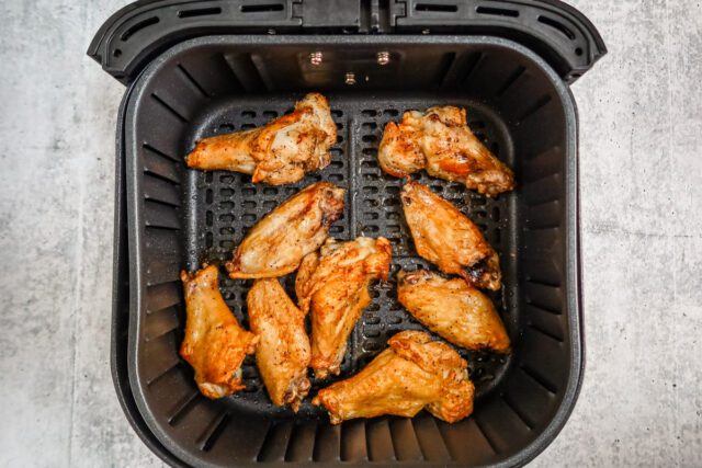 Cooked air fryer chicken wings in the basket.