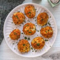 A plate of homemade air fryer potato croquettes made with leftover mashed potatoes, cheese, and herbs.
