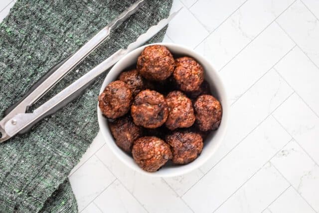 Crispy cooked meatballs in a white bowl.