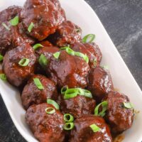 Air fryer meatballs with BBQ sauce in a serving tray.