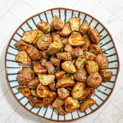 Roasted diced potatoes with herbs and seasoning.