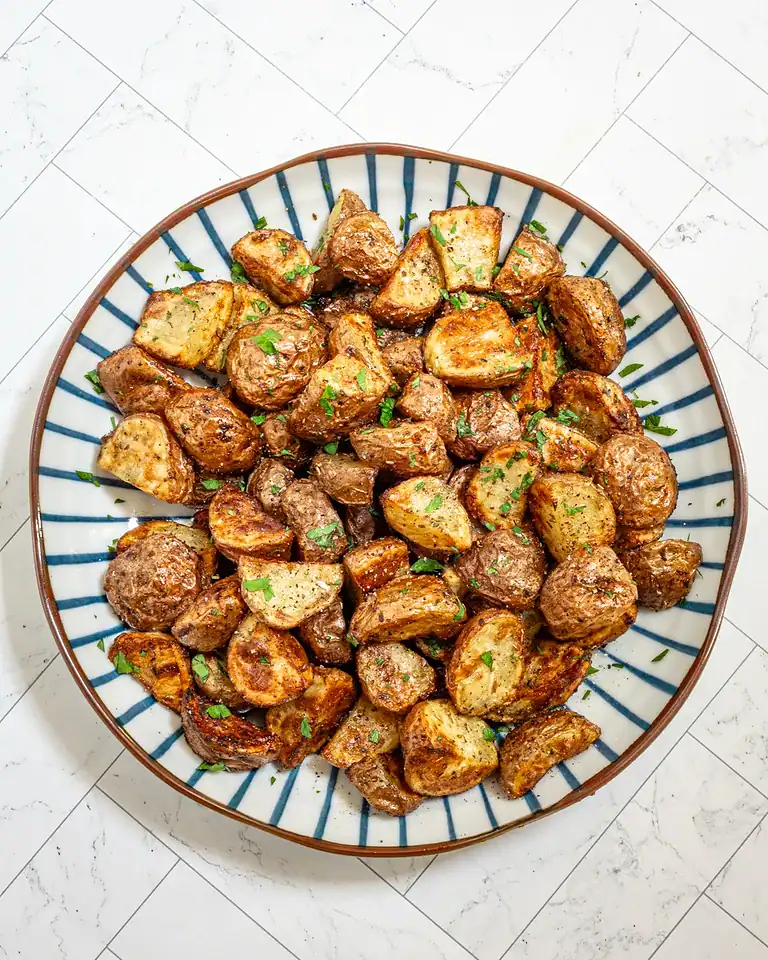 Roasted diced potatoes with herbs and seasoning.