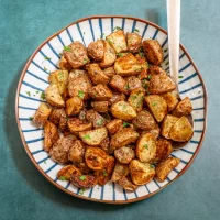 Roasted potato chunks sprinkled with chopped fresh herbs.