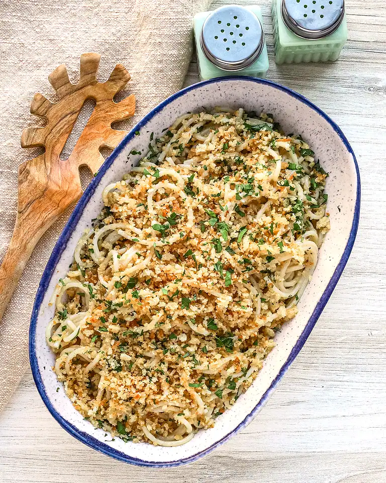 Golden breadcrumb-topped pasta dish garnished with herbs.