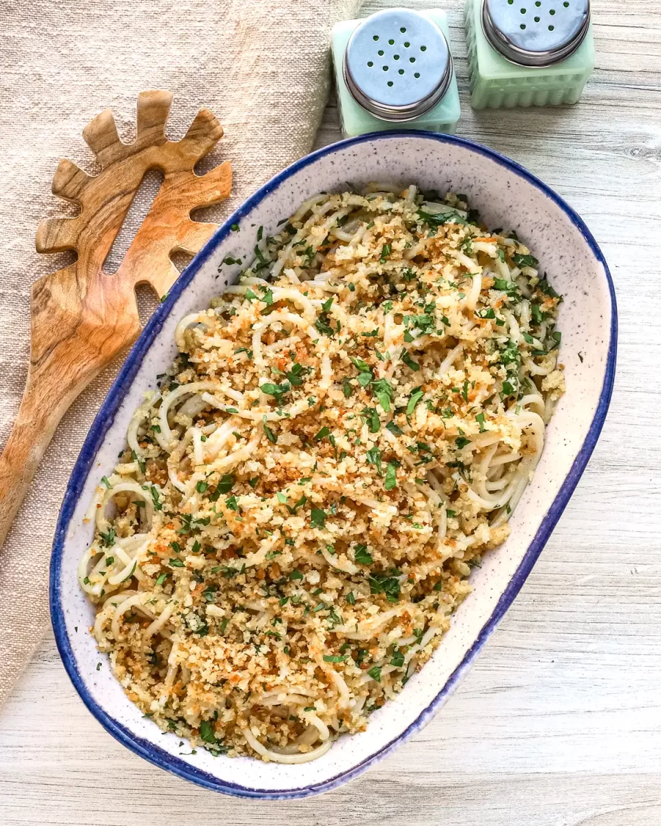 Golden breadcrumb-topped pasta dish garnished with herbs.