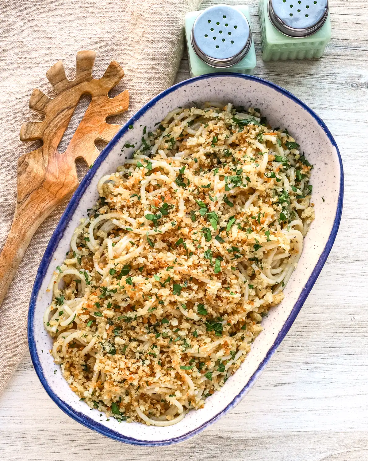 Golden breadcrumb-topped pasta dish garnished with herbs.