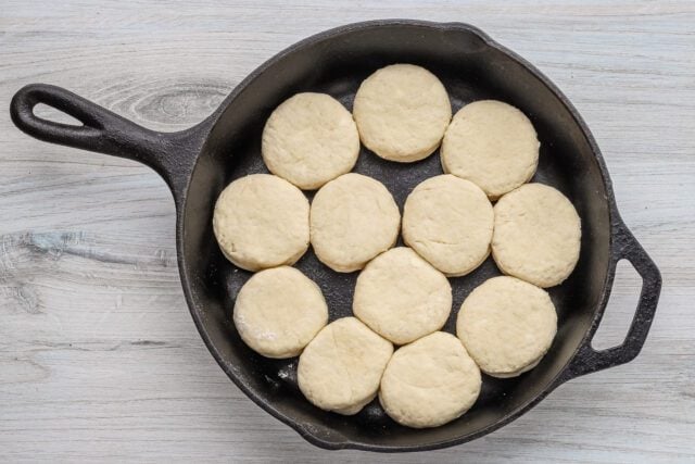 Golden biscuit dough balls in a cast iron skillet.