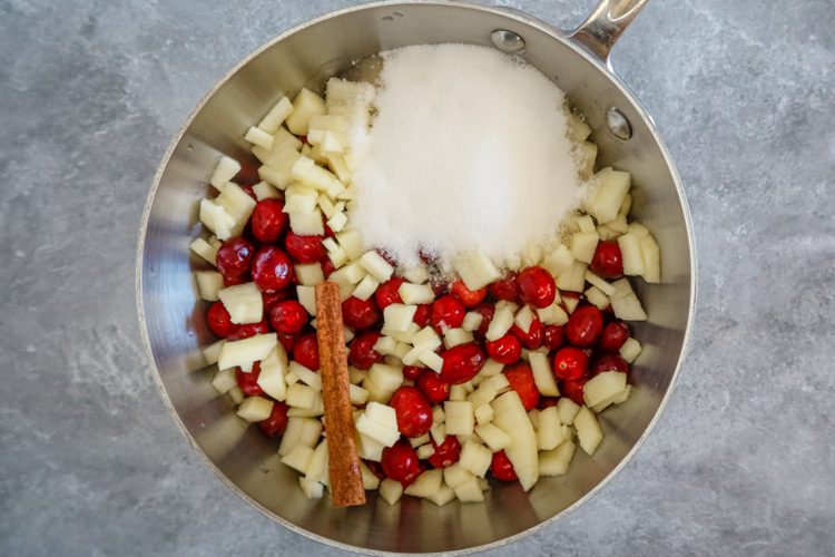 Cranberry sauce preparation with ingredients in the saucepan.