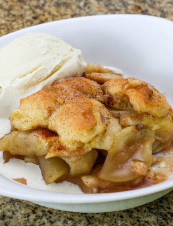 best ever apple cobbler in a serving dish with a scoop of ice cream